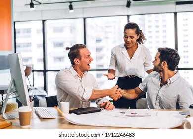 Image Two Business Partners Successful Handshake Together In Front Of Teamwork Casual Business Winning Success Agreement In Modern Office.Partnership Approval And Teamwork