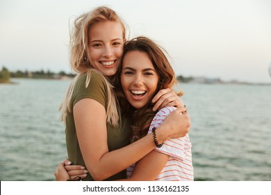 Image of two happy women friends hugging outdoors on the beach. - Powered by Shutterstock