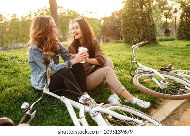 Image Of Two Young Beautiful Women Friends Outdoors With Bicycles In Park.