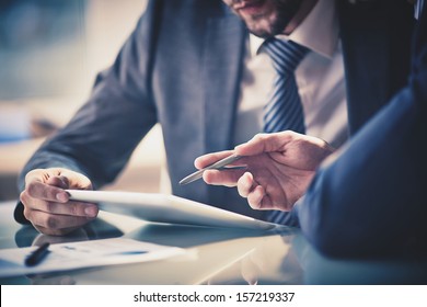 Image of two young businessmen using touchpad at meeting - Shutterstock ID 157219337