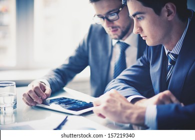 Image Of Two Young Businessmen Using Touchpad