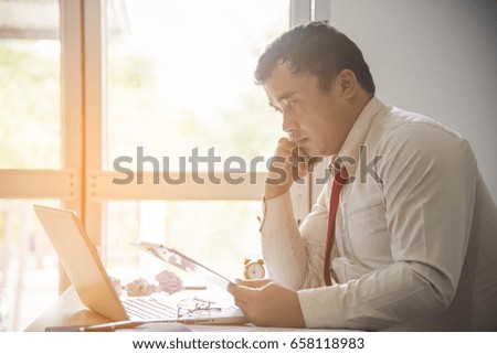 Image of two young businessmen using touch pad at meeting