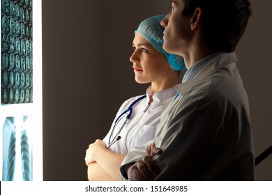 Image of two young two doctors discussing x-ray results