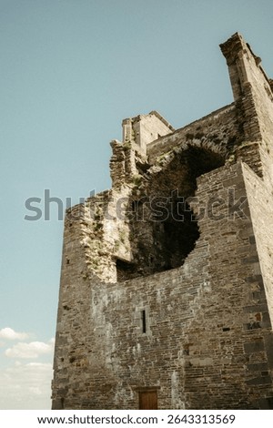 Image of the upper part of an ancient castle with a large hole in it