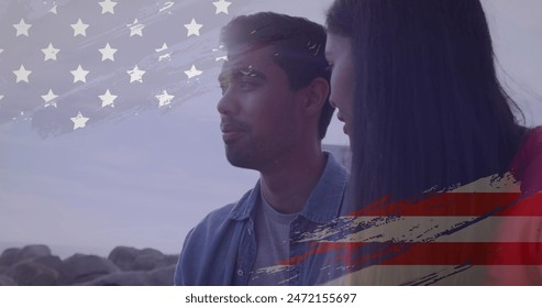 Image of usa flag effect against biracial couple talking to each other at the beach. Independence day celebration and holiday concept - Powered by Shutterstock