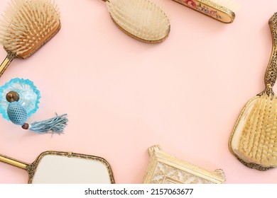 Image Of Vintage Hair Comb, Perfume Bottle And Hand Mirror Over Pastel Pink Background