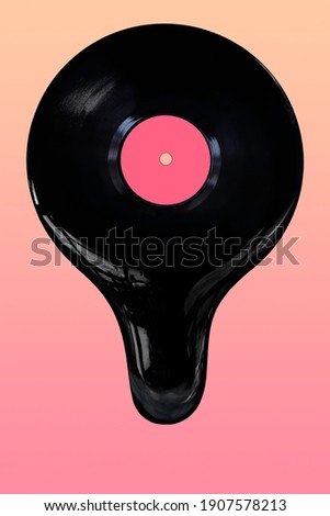 An image of a vinyl record melting and dripping from the bottom. Pink and orange background and straight on view of record.