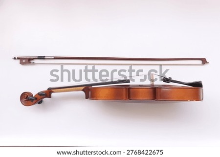 Image of a violin with a bow, a string instrument typically used in classical and folk music on white background. 