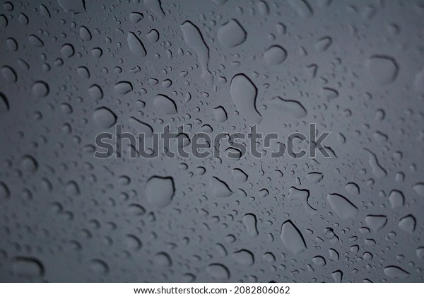 Image of water droplets on the\
windshield of a car in the time after the rain the sky is\
gray