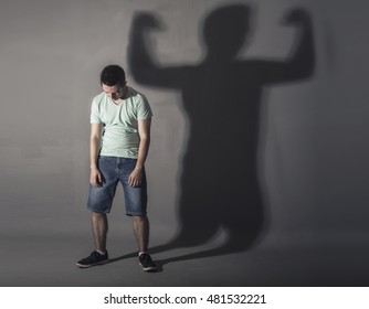 Image Of A Weak Man Standing Depressed In Front Of A Wall And His Shadow Shows Streght