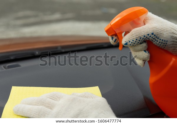Image of a white gloved hand with a yellow\
microfiber cloth to wash the car interior. Detergents for cleaning\
of salon of the vehicle