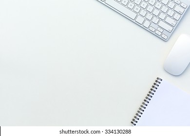 Abbildung eines Weißbüchertisches mit Computertastatur und Draufsicht von Papier-Notepad