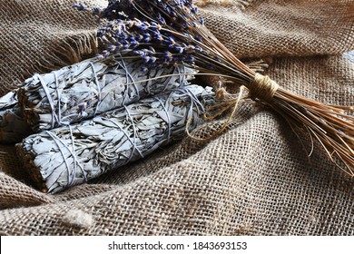 An Image Of White Sage Smudge Sticks And Dried Lavender Flowers On Vintage Burlap Cloth. 