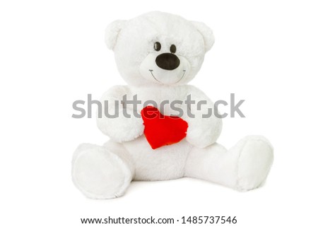 Image of white toy teddy bear holding red heart and sitting at isolated white background.