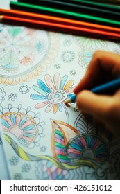 Image Of Woman Coloring, Adult Coloring Book Trend, For Stress Relief. Top View. Colorer - Antistress With Colored Pencils. Adult Coloring Books. The Woman Draws Thereby Relieves Stress