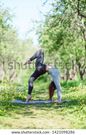Image of woman doing yoga on blue rug in woods