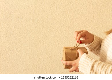 image of a woman's hands with red nails, opening a gift.Christmas gift. love concept. - Shutterstock ID 1835262166