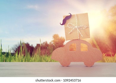 Image Of Wooden Car With Gift Box On The Roof, Present For Dad. Father's Day Concept