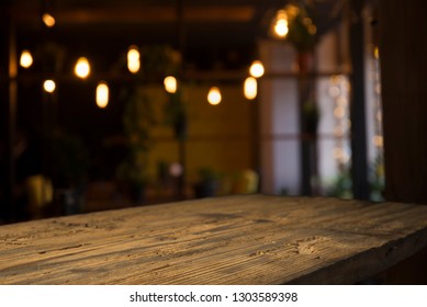 Image Of Wooden Table In Front Of Abstract Blurred Background Of Resturant Lights