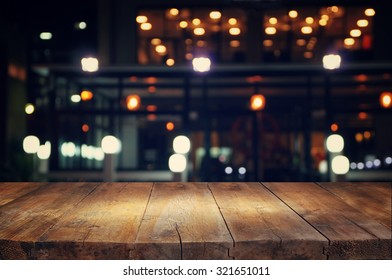 image of wooden table in front of abstract blurred background of resturant lights
 - Shutterstock ID 321651011