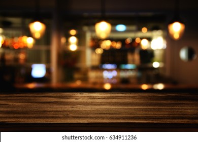 Image of wooden table in front of abstract blurred restaurant lights background. - Shutterstock ID 634911236