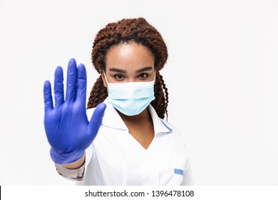 Image Of Young African American Nurse Or Doctor Woman Wearing Medical Face Mask And Disposable Gloves Showing Stop Gesture Isolated Against White Background