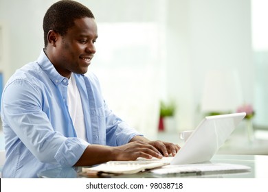 Image Of Young African Man Typing On Laptop