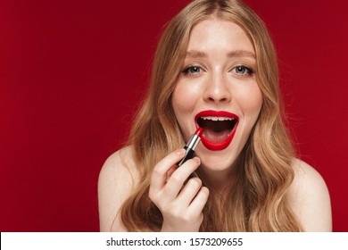 Image of young amazing caucasian woman posing isolated over red wall background apply bright red lipstick.