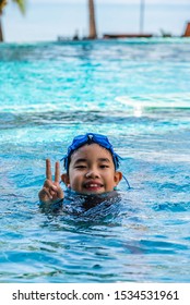 Image Of Young Asian Boy At Swimming Pool In Resort Near The Beach Day Time.