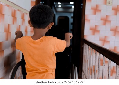 An image of a young Asian boy using a wheelchair, standing at the doorway of his home