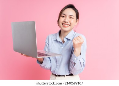 Image Of Young Asian Business Woman Holding Laptop On Pink Background