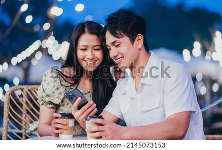 Image of young Asian couple dating at coffee shop