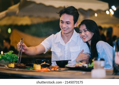 Image of young Asian couple eating dinner together