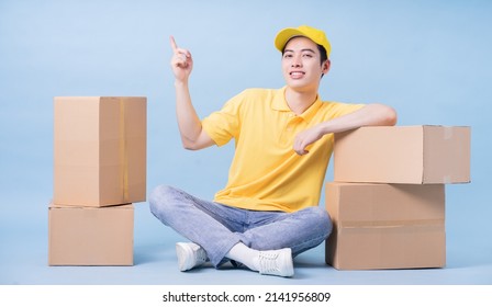 Image Of Young Asian Delivery Man On Blue Background