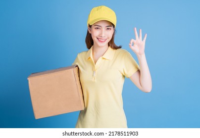 Image Of Young Asian Delivery Woman On Blue Background