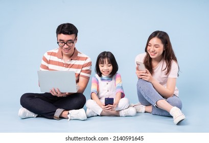 Image Of Young Asian Family Using Laptop On Blue Background