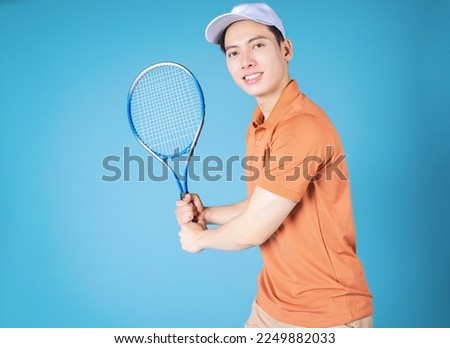 Image of young Asian man holding tennis racket