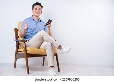 Image Of Young Asian Man Sitting On Chair