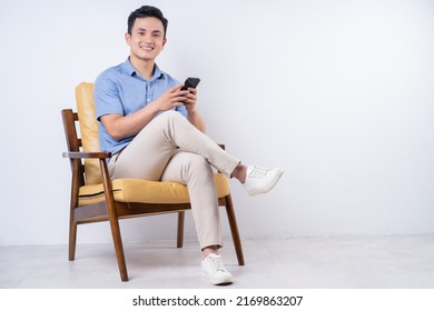 Image Of Young Asian Man Sitting On Chair