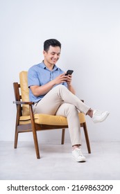 Image Of Young Asian Man Sitting On Chair