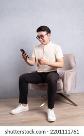 Image Of Young Asian Man Sitting On Chair