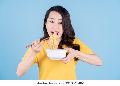 Image of young Asian woman eating instant noodles