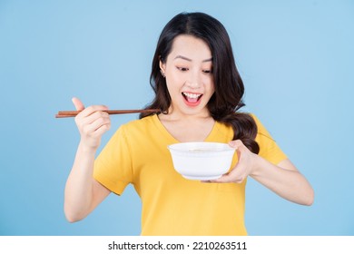 Image of young Asian woman holding chopstick and bowl