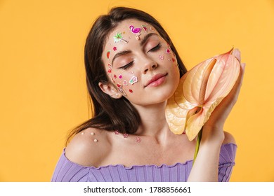 Image Of Young Beautiful Woman With Stickers On Face Holding Exotic Flower Isolated Over Yellow Background