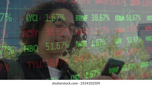 Image of young biracial man checks stock market updates on his phone. he outdoors, engaged with his mobile amidst digital financial data overlay, slow motion. - Powered by Shutterstock