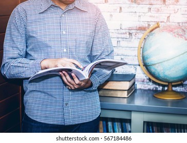 Image Of Young  Business Man  Reading Magazine  At Office With Burred Of World Globe Background