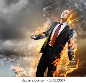 Image of young businessman in anger burning in fire