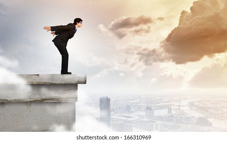 Image Of Young Businessman In Goggles Jumping From Top Of Building