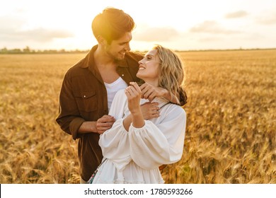 Image of young caucasian beautiful couple hugging together in golden field on countryside - Shutterstock ID 1780593266