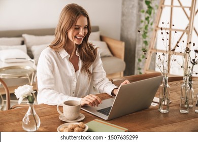 Image of young cheery happy positive cute beautiful business woman sit indoors in office using laptop computer. - Shutterstock ID 1507635299